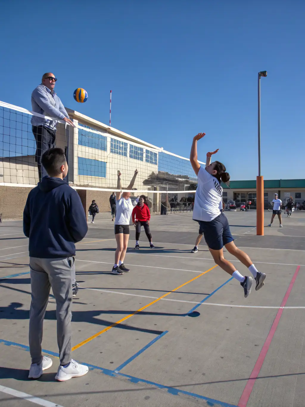 A group of students practicing volleyball, demonstrating communication, strategy, and sportsmanship, representing the volleyball program offered by ASSOCIATION SPORTIVE ET CULTURELLE LA SAULE.