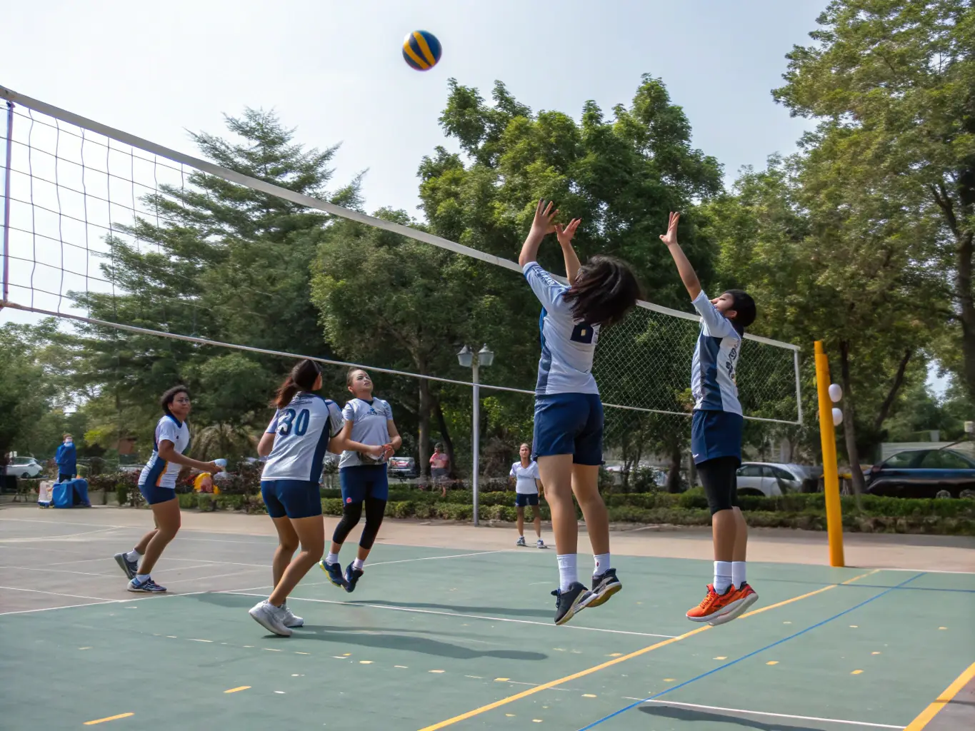 A group of students practicing volleyball outdoors, emphasizing agility and coordination.
